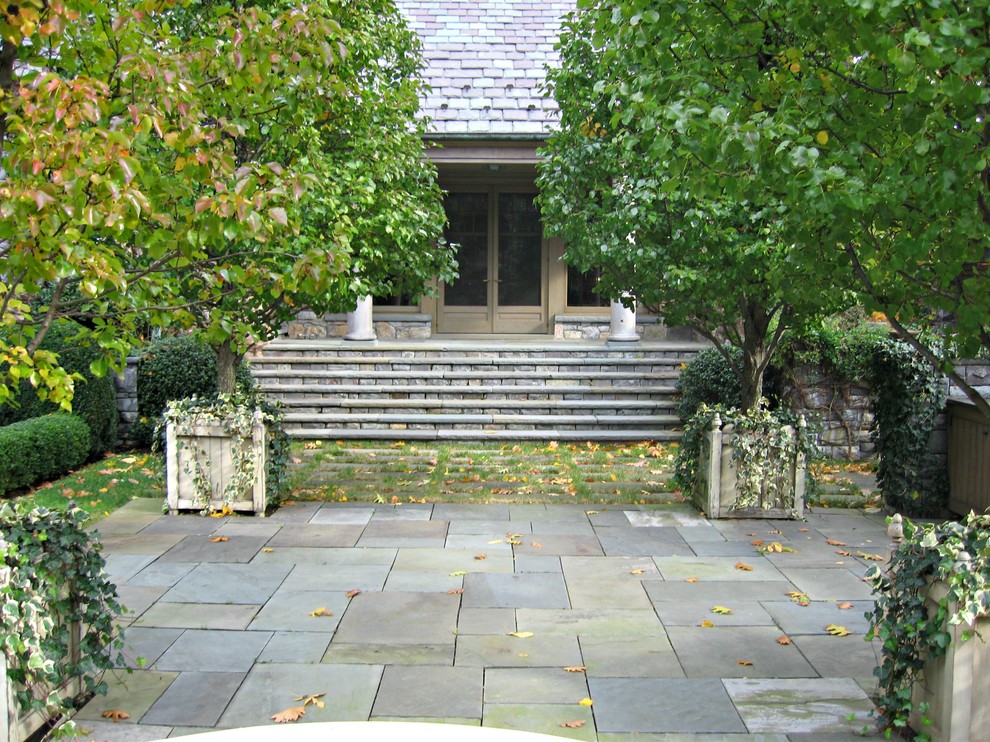 Imagen de terraza campestre extra grande en patio delantero con adoquines de piedra natural