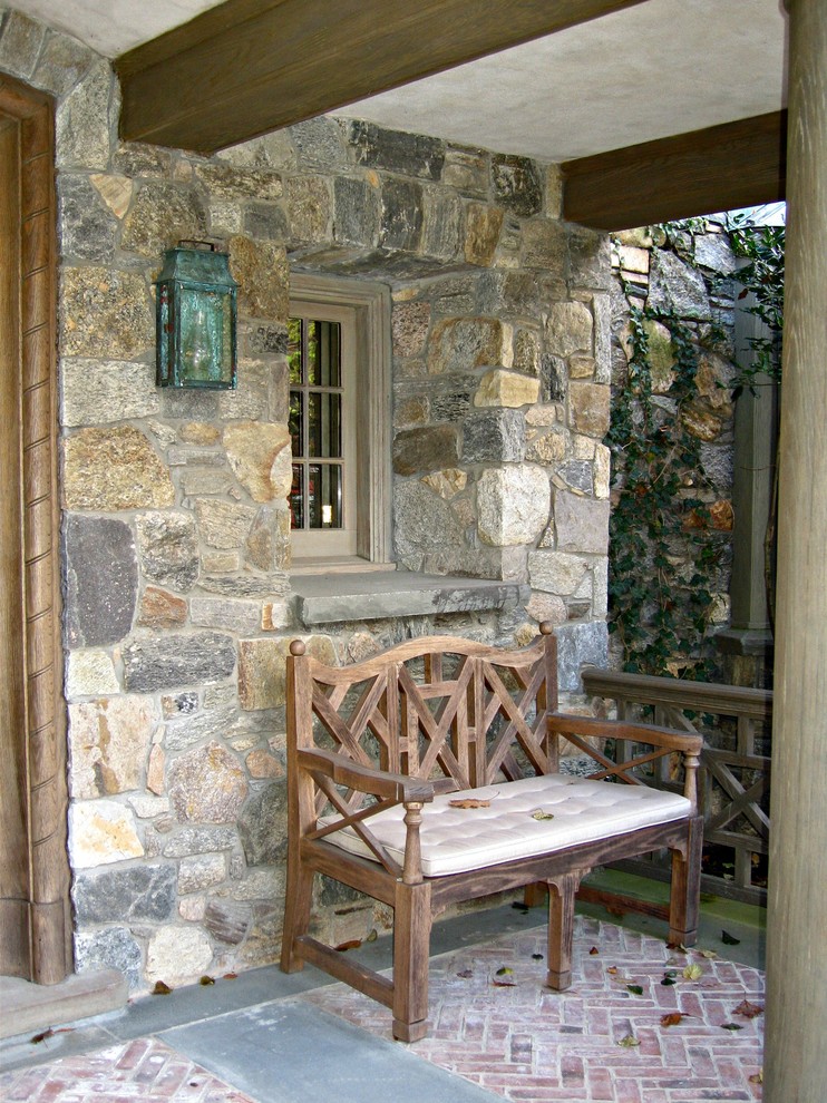 Inspiration pour un très grand porche d'entrée de maison arrière rustique avec des pavés en brique et une extension de toiture.