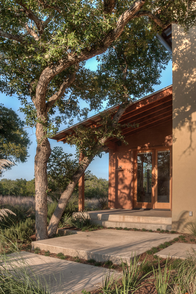 Inspiration for a mid-sized contemporary concrete porch remodel in Austin with a roof extension