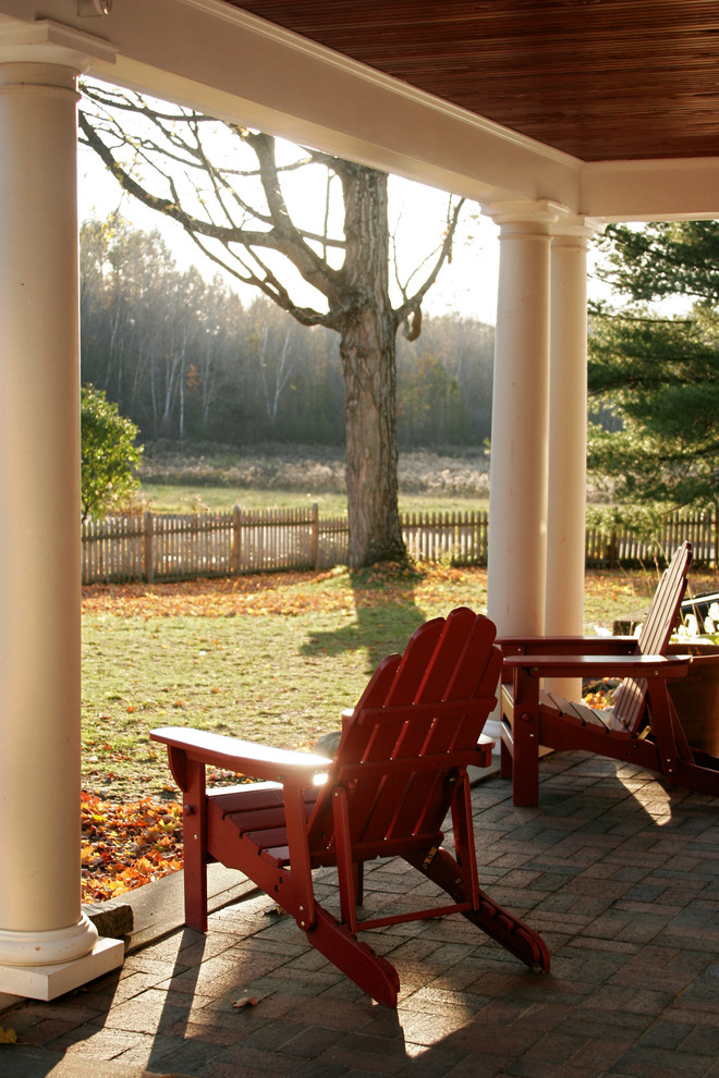 This is an example of a traditional brick porch design in Boston with a roof extension.