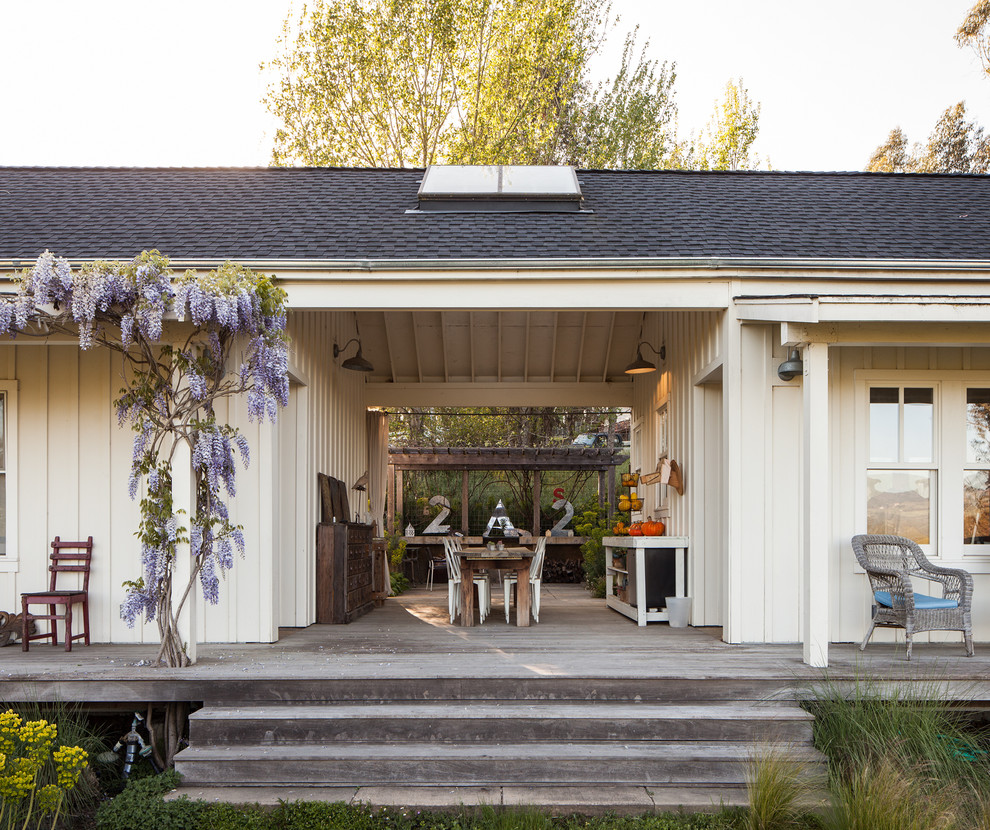 Cette image montre un porche d'entrée de maison rustique avec une terrasse en bois et une extension de toiture.