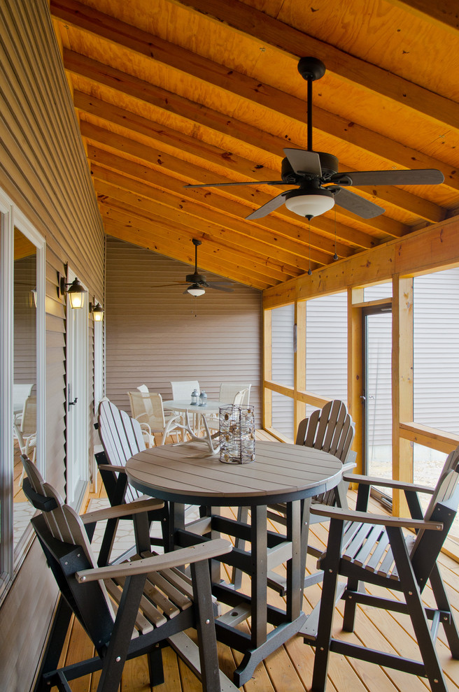Inspiration pour un porche d'entrée de maison arrière chalet de taille moyenne avec une moustiquaire, une terrasse en bois et une extension de toiture.