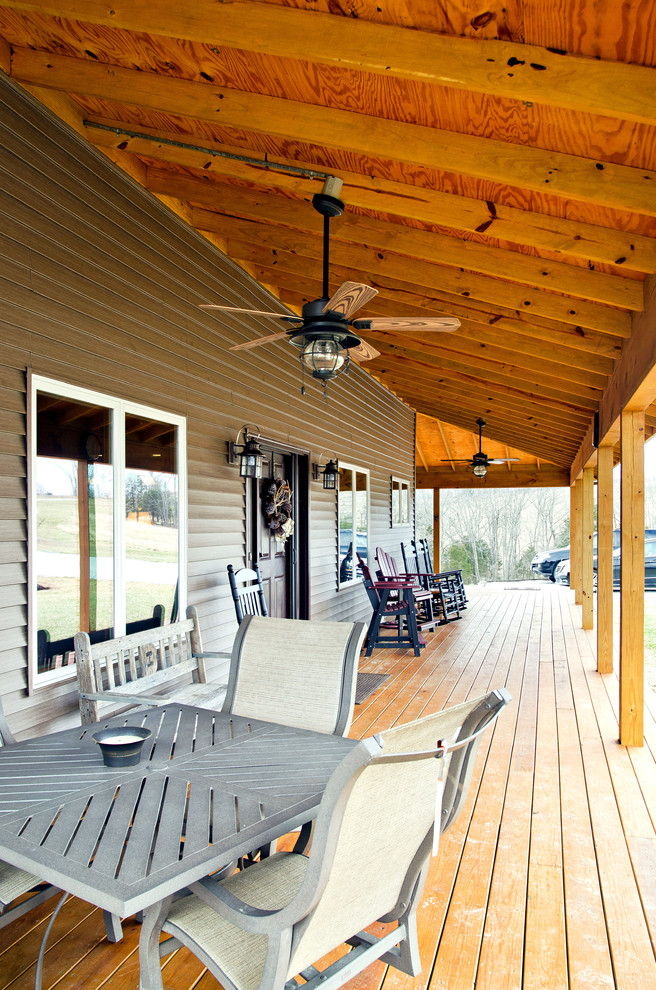 Bild på en mellanstor rustik veranda framför huset, med trädäck och takförlängning