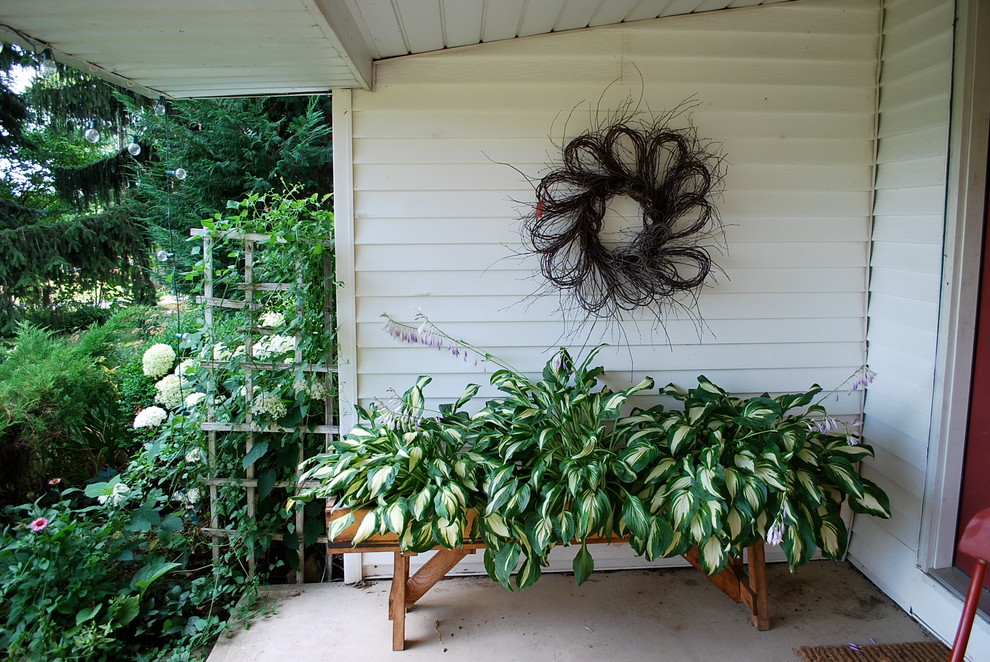 Источник вдохновения для домашнего уюта: веранда среднего размера на переднем дворе в стиле кантри с вертикальным садом, мощением тротуарной плиткой и навесом