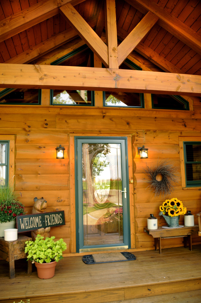 Inspiration pour un petit porche d'entrée de maison avant chalet avec une dalle de béton et une extension de toiture.