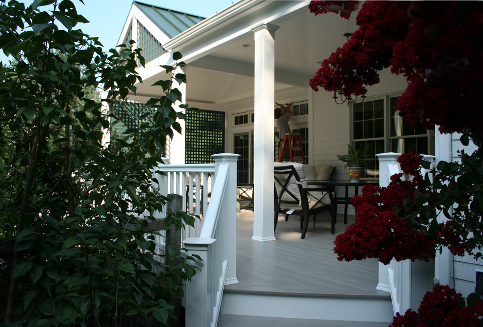 This is an example of a large traditional screened-in back porch design in New York with decking and a roof extension.