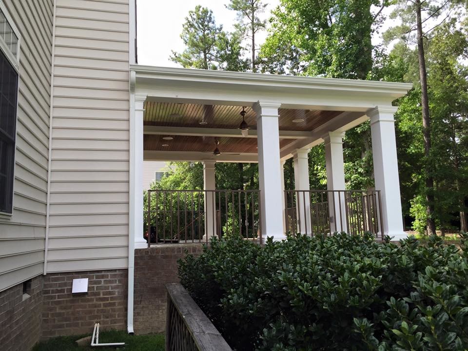 Foto di un portico stile americano di medie dimensioni e dietro casa con un portico chiuso, pavimentazioni in mattoni e un tetto a sbalzo