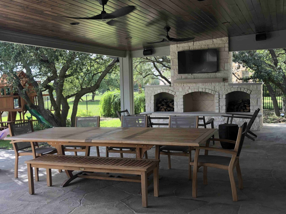 This is an example of a huge eclectic back porch design in Austin with a fireplace.