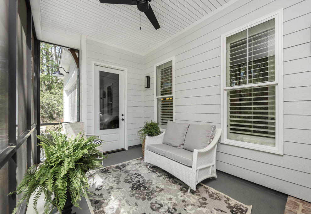 Cette image montre un petit porche d'entrée de maison latéral rustique avec une moustiquaire, une dalle de béton et une extension de toiture.