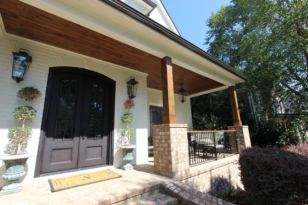 Medium sized classic front veranda in Atlanta with concrete slabs and a roof extension.