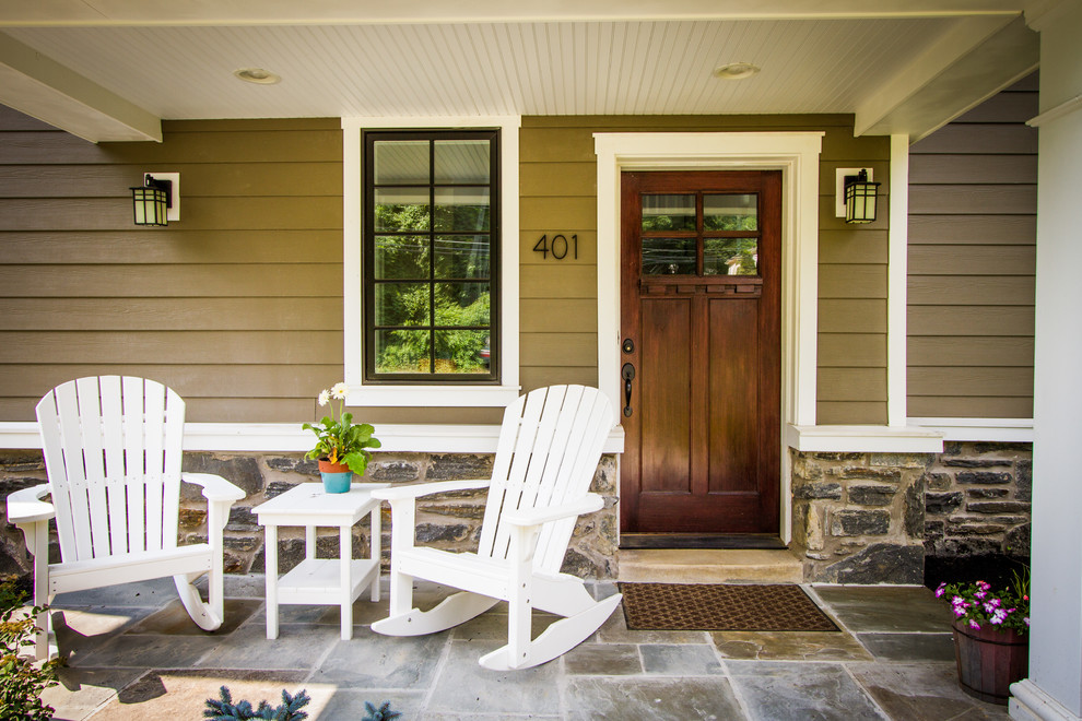 Mid-sized elegant stone front porch photo in Philadelphia with a roof extension