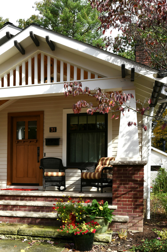 Inspiration for a small craftsman front porch remodel in Cleveland with a roof extension