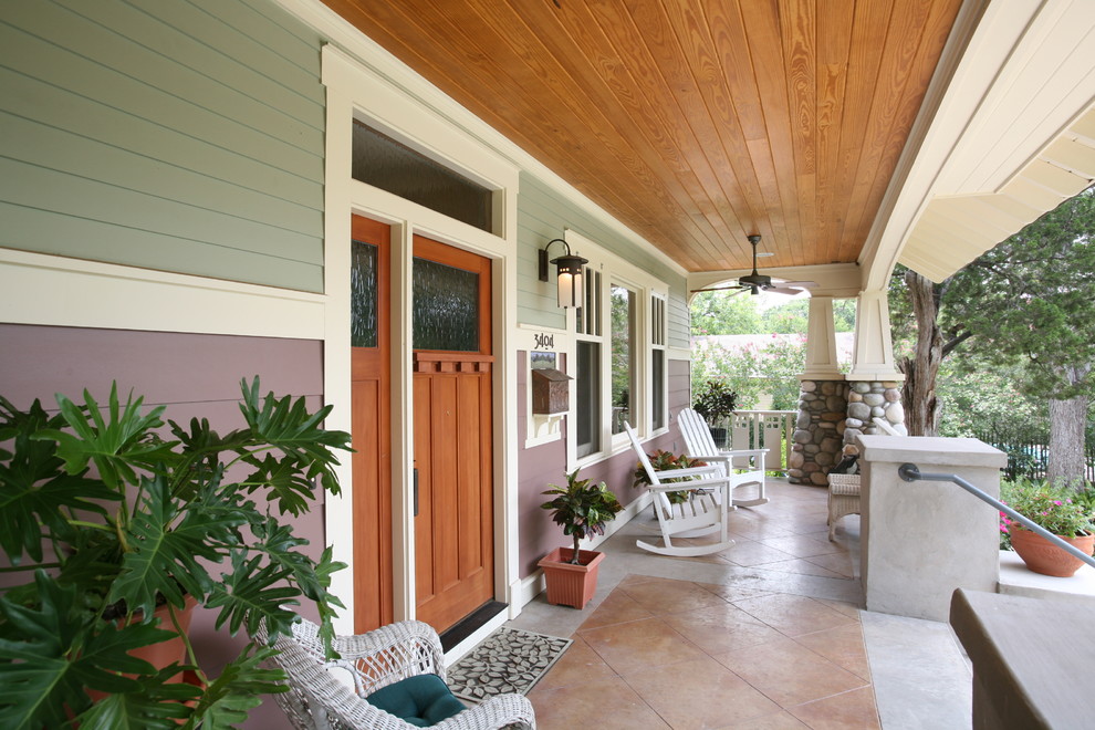 This is an example of a craftsman tile front porch design in Austin with a roof extension.
