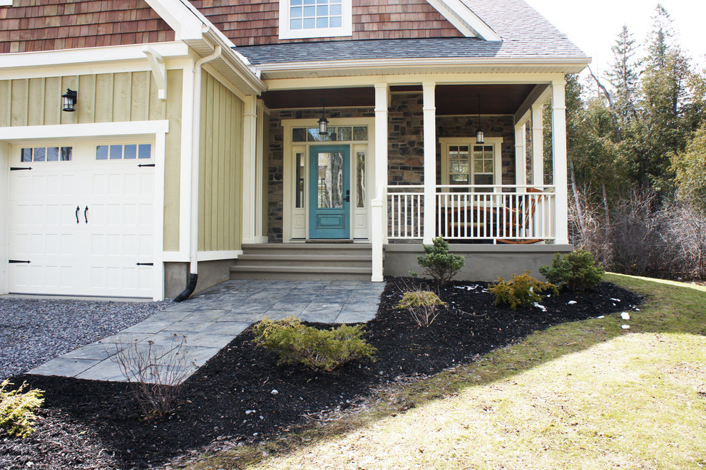 Foto di un portico chic di medie dimensioni e davanti casa con pavimentazioni in pietra naturale e un tetto a sbalzo