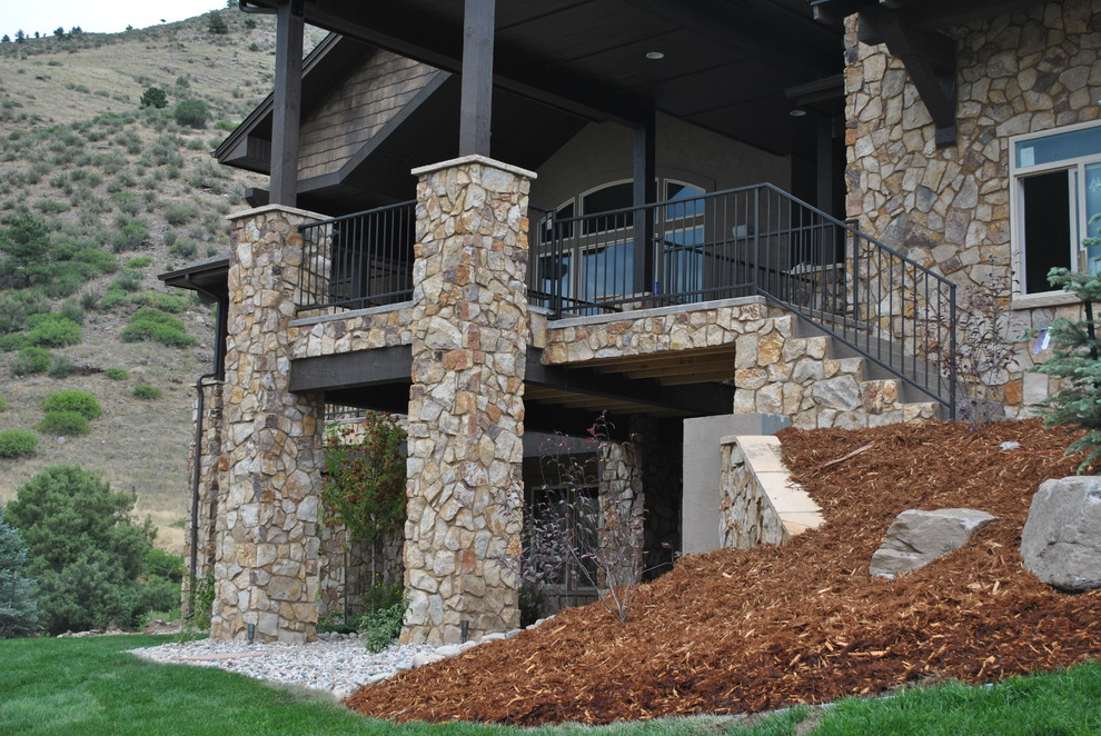 Exemple d'un grand porche d'entrée de maison arrière montagne avec une extension de toiture et une dalle de béton.