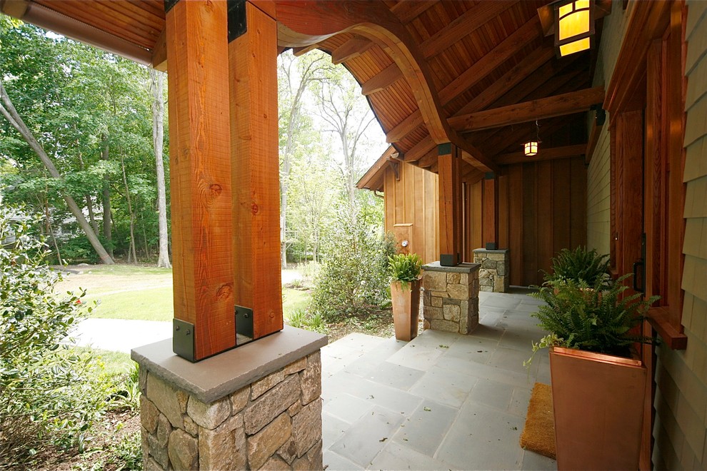 Idee per un portico stile rurale di medie dimensioni e davanti casa con pavimentazioni in pietra naturale e un tetto a sbalzo
