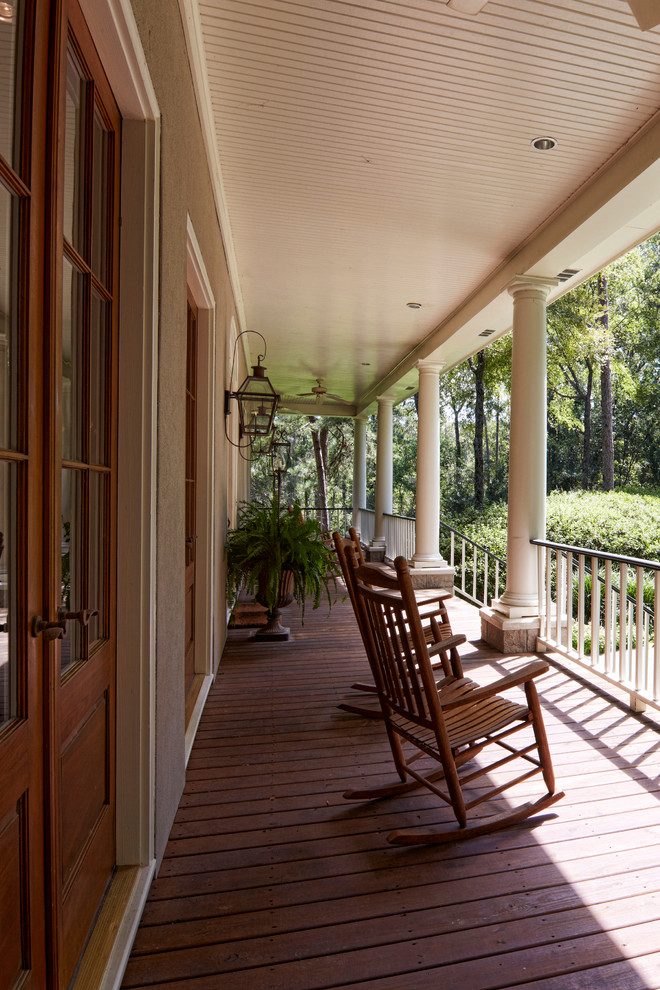 This is an example of a mid-sized traditional front porch design in Austin with decking and a roof extension.