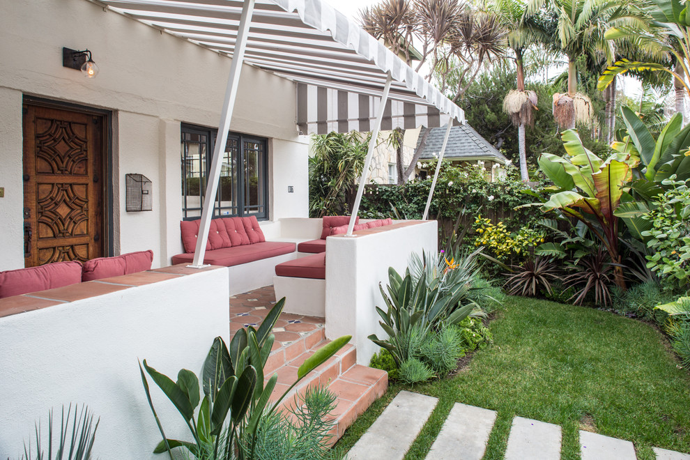 This is an example of a mediterranean tile porch design in Los Angeles with an awning.