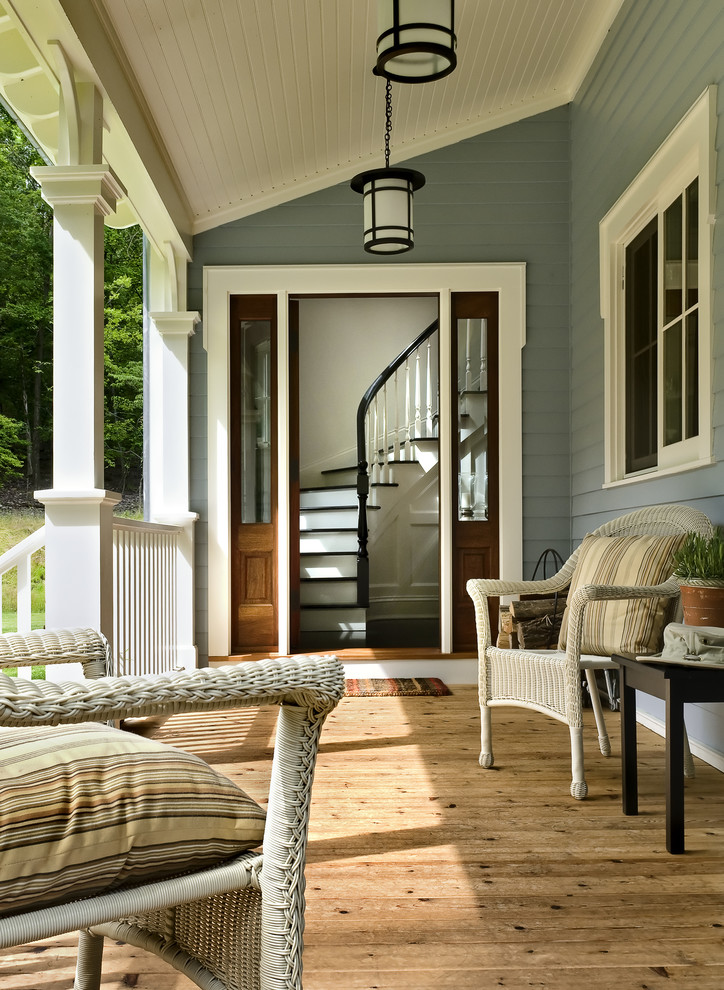Idée de décoration pour un porche d'entrée de maison tradition avec une terrasse en bois et une extension de toiture.