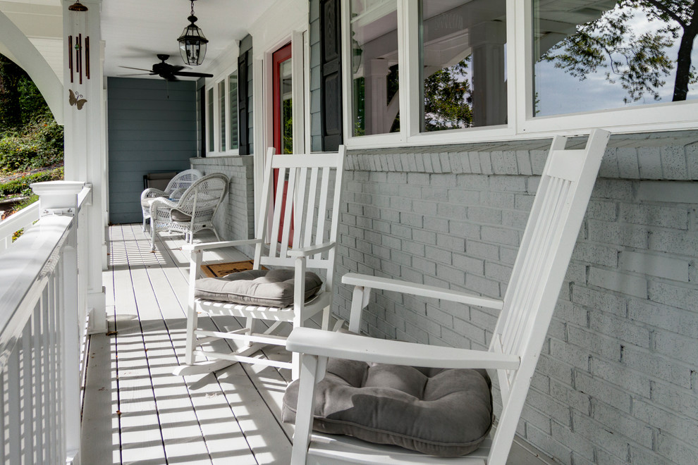 Modelo de terraza clásica renovada de tamaño medio en patio delantero y anexo de casas con entablado