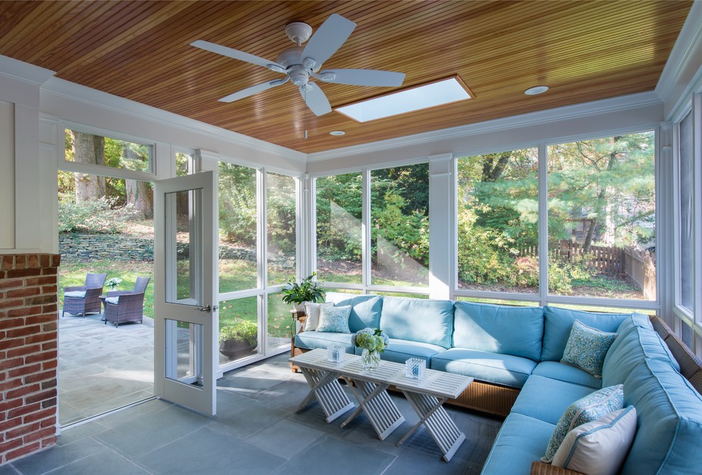 Idée de décoration pour un porche d'entrée de maison arrière tradition de taille moyenne avec une moustiquaire, des pavés en pierre naturelle et une extension de toiture.