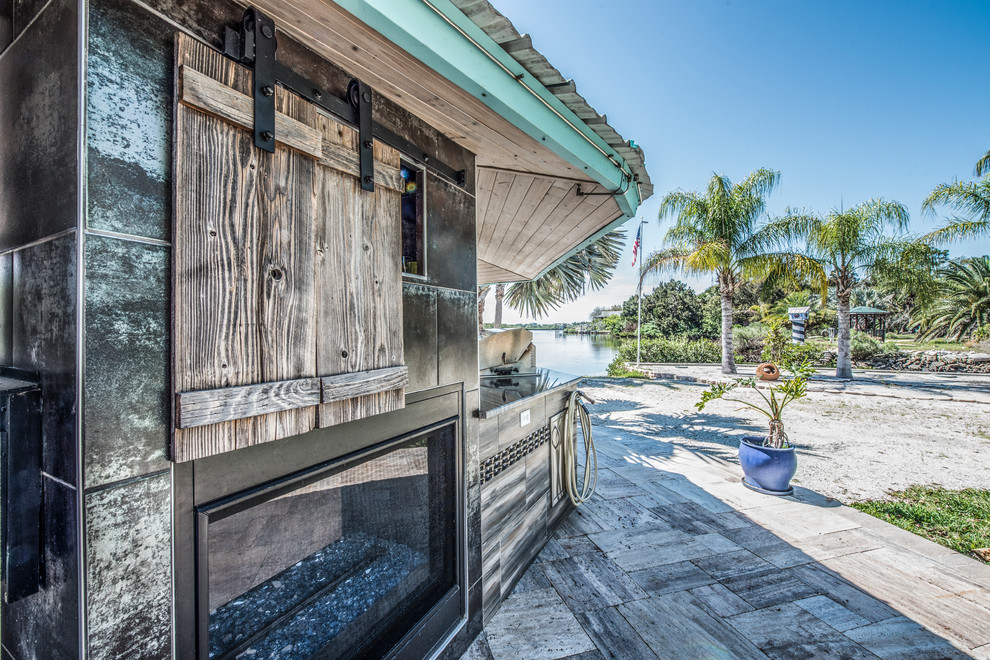 Idées déco pour un très grand porche d'entrée de maison arrière bord de mer avec une cuisine d'été et des pavés en béton.