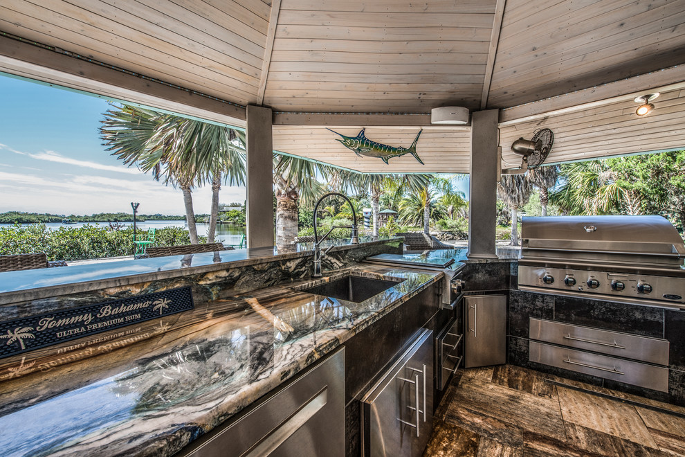 Cette image montre un très grand porche d'entrée de maison arrière marin avec une cuisine d'été et des pavés en béton.