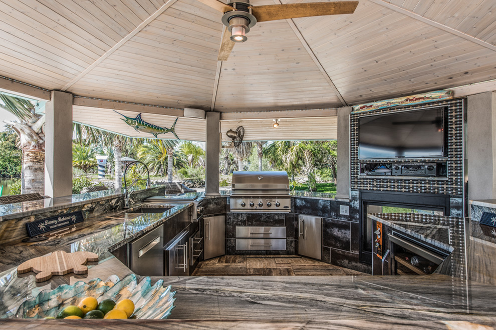 Cette photo montre un très grand porche d'entrée de maison arrière bord de mer avec une cuisine d'été et des pavés en béton.