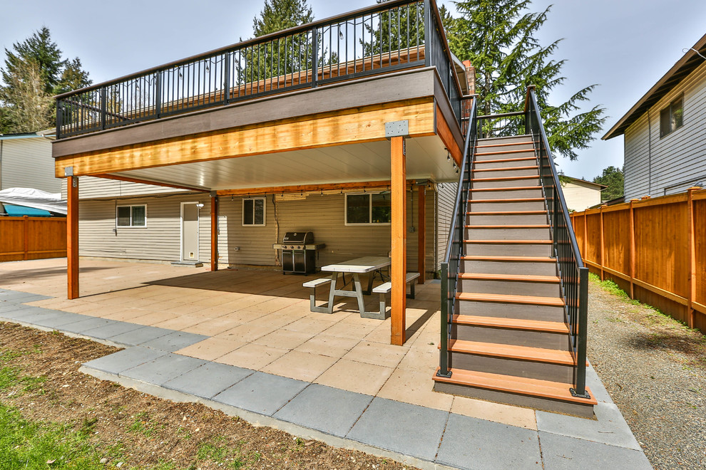 Cette photo montre un grand porche d'entrée de maison arrière craftsman avec du carrelage et une extension de toiture.