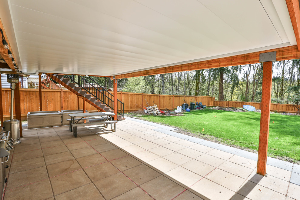Imagen de terraza de estilo americano grande en patio trasero y anexo de casas con suelo de baldosas