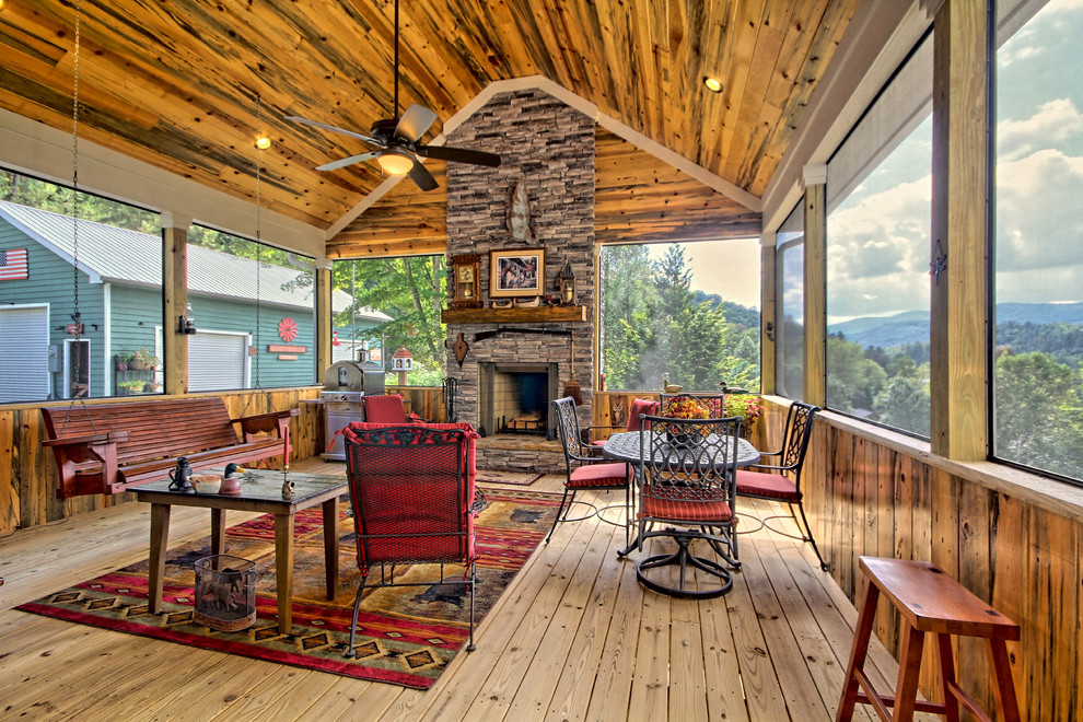 Idée de décoration pour un porche d'entrée de maison chalet avec une terrasse en bois, une extension de toiture et tous types de couvertures.