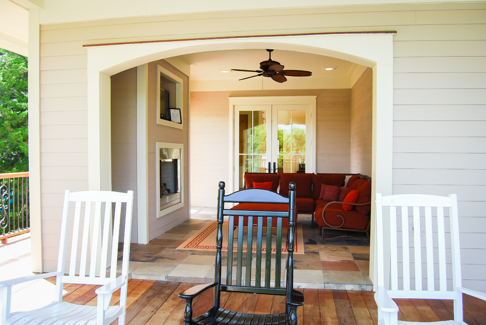 Mid-sized cottage stone back porch idea in Charleston with a fireplace and a roof extension
