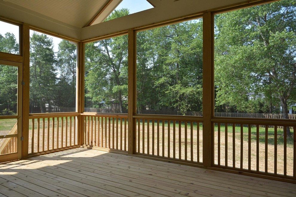 Inspiration pour un grand porche d'entrée de maison arrière craftsman avec une moustiquaire et une extension de toiture.