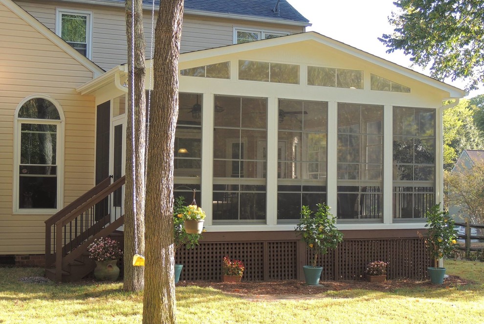 Exemple d'un porche d'entrée de maison arrière chic de taille moyenne avec une moustiquaire, une terrasse en bois et une extension de toiture.