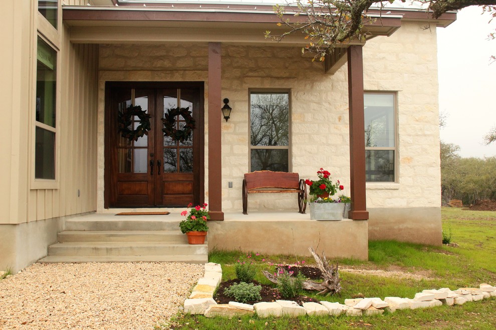 Foto på en mellanstor amerikansk veranda framför huset, med naturstensplattor och takförlängning