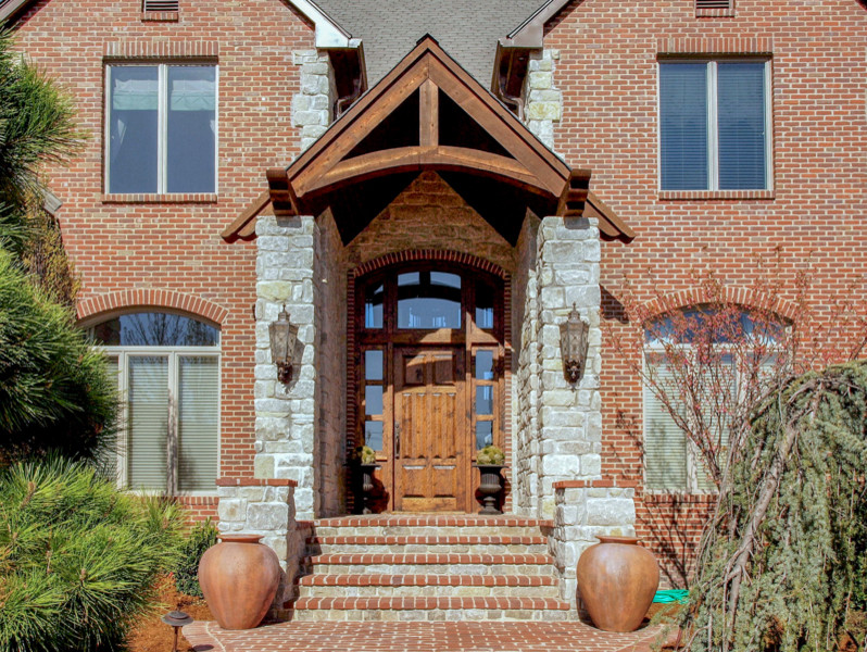 Esempio di un portico rustico di medie dimensioni e davanti casa con pavimentazioni in mattoni