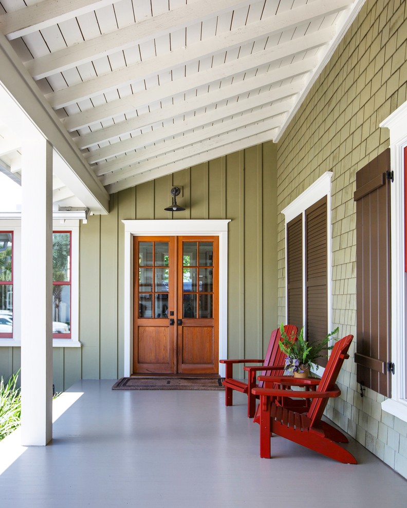Idée de décoration pour un porche d'entrée de maison avant marin avec une dalle de béton et une extension de toiture.