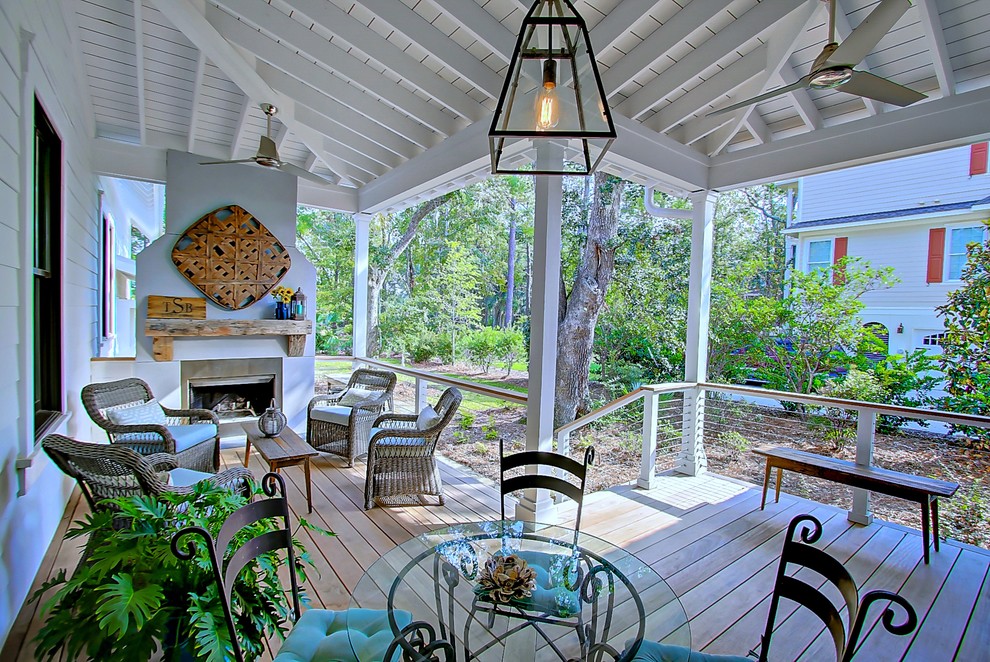 Idéer för en stor lantlig veranda på baksidan av huset, med en öppen spis, trädäck och takförlängning