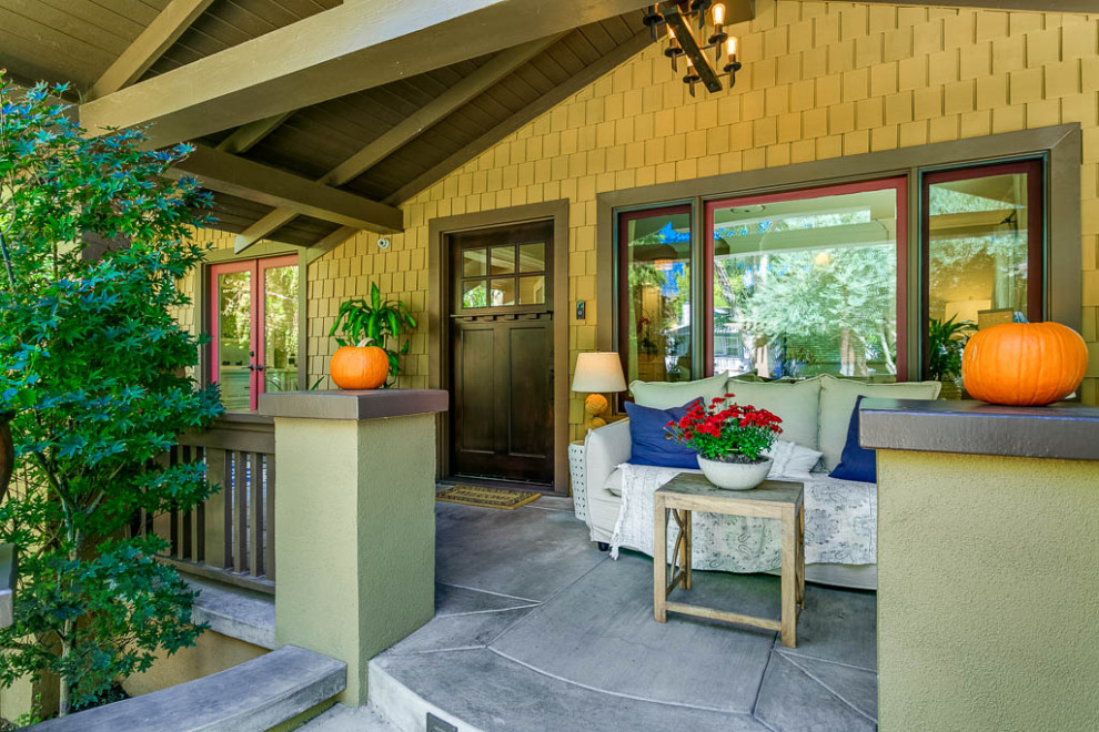 This is an example of a mid-sized craftsman concrete front porch design in Los Angeles with a roof extension.