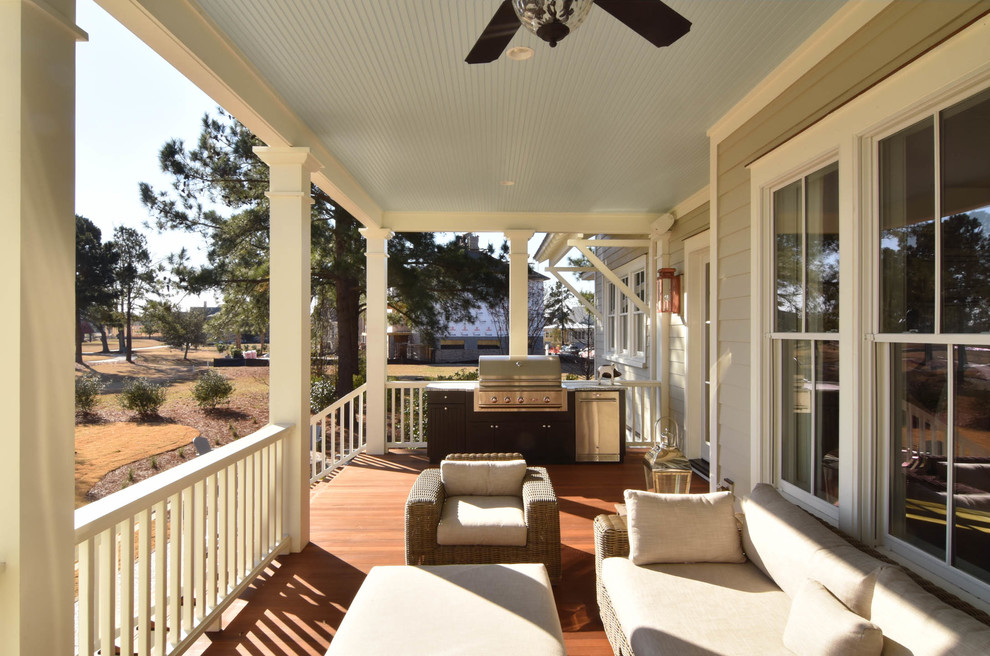 Exemple d'un porche d'entrée de maison avant chic de taille moyenne avec une cuisine d'été, une terrasse en bois et une extension de toiture.