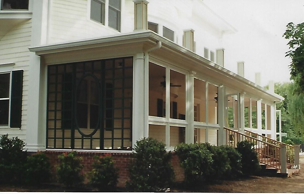 Exempel på en mellanstor klassisk innätad veranda på baksidan av huset, med takförlängning