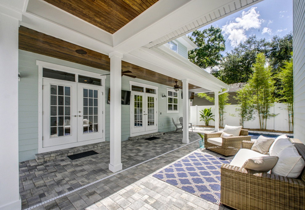 Exemple d'un porche d'entrée de maison arrière bord de mer de taille moyenne avec des pavés en béton et une extension de toiture.