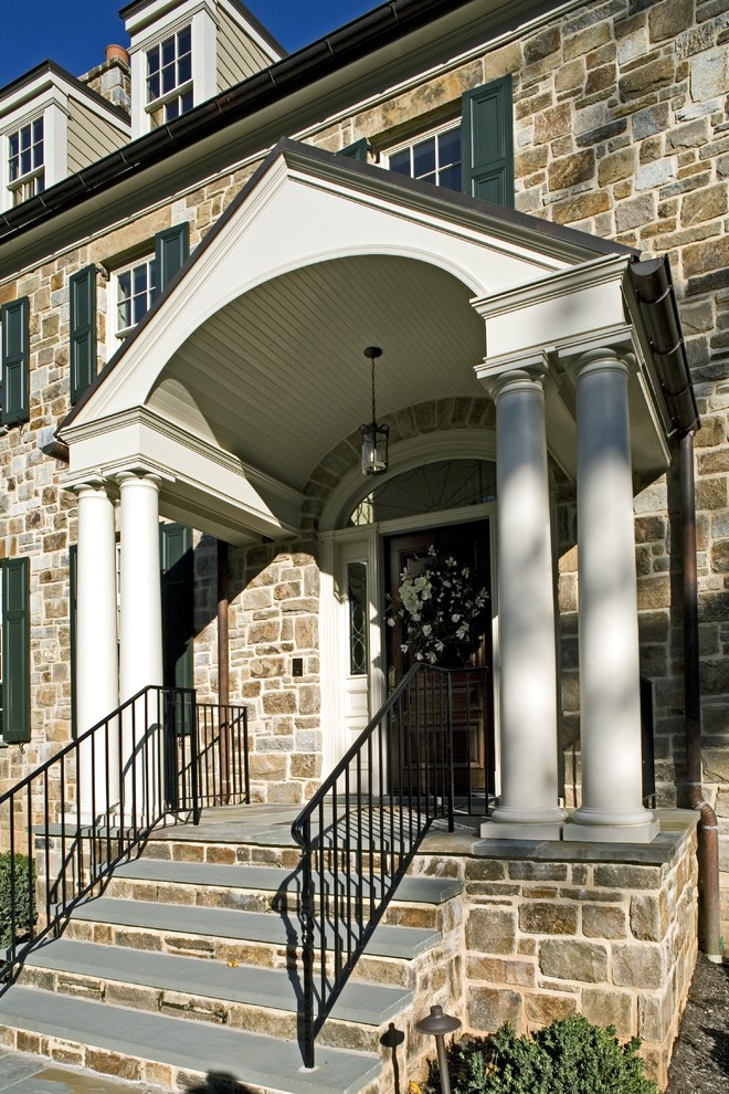 Esempio di un portico classico davanti casa con pavimentazioni in pietra naturale e un tetto a sbalzo