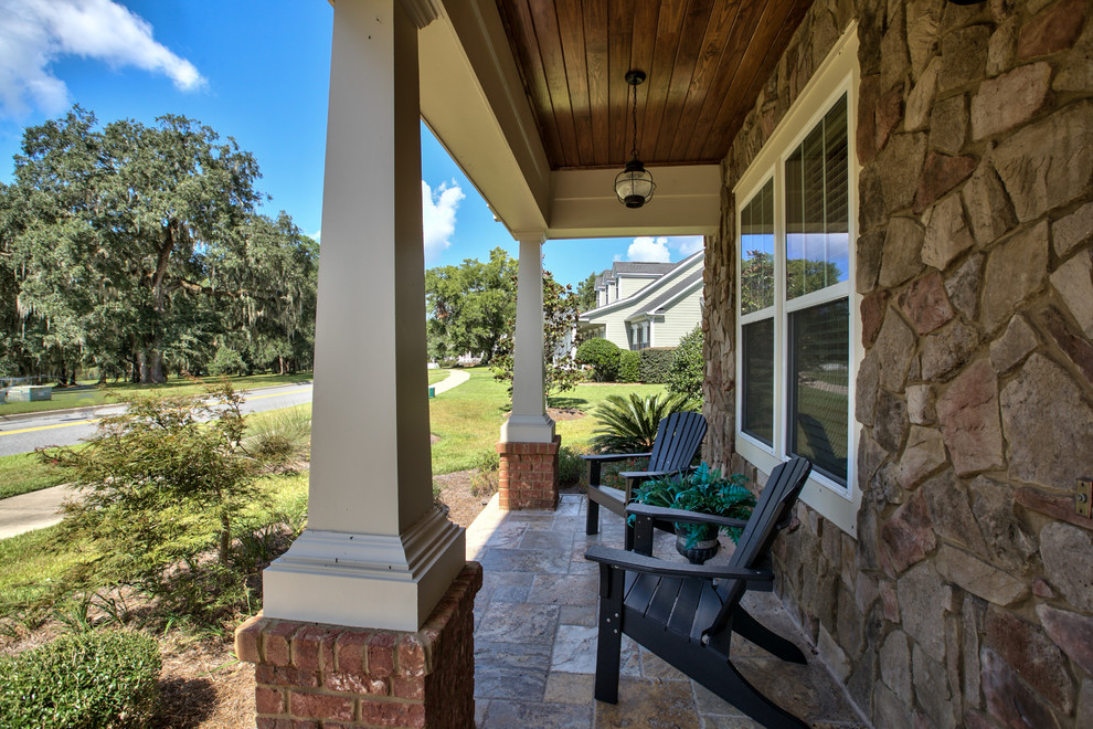 This is an example of a large craftsman tile front porch design in Atlanta with a roof extension.