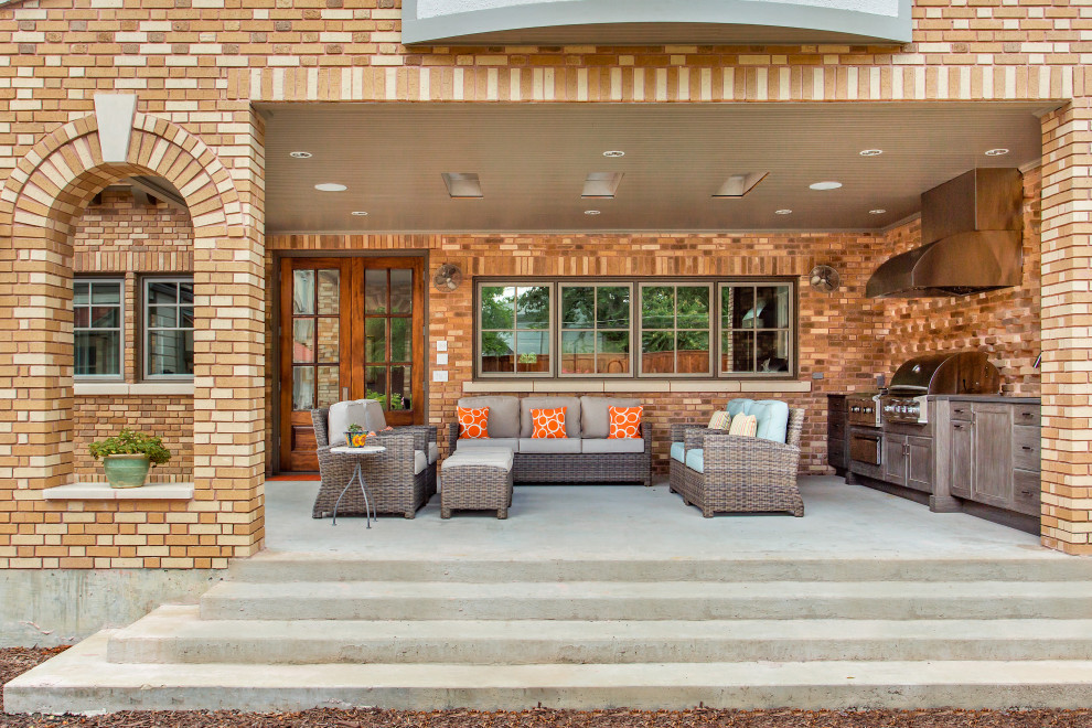 This is an example of a medium sized traditional veranda in Dallas with an outdoor kitchen, concrete slabs and a roof extension.