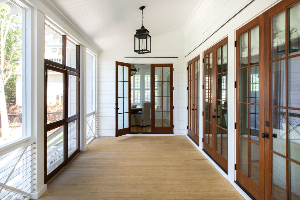 Idéer för mellanstora vintage innätade verandor framför huset, med trädäck och takförlängning