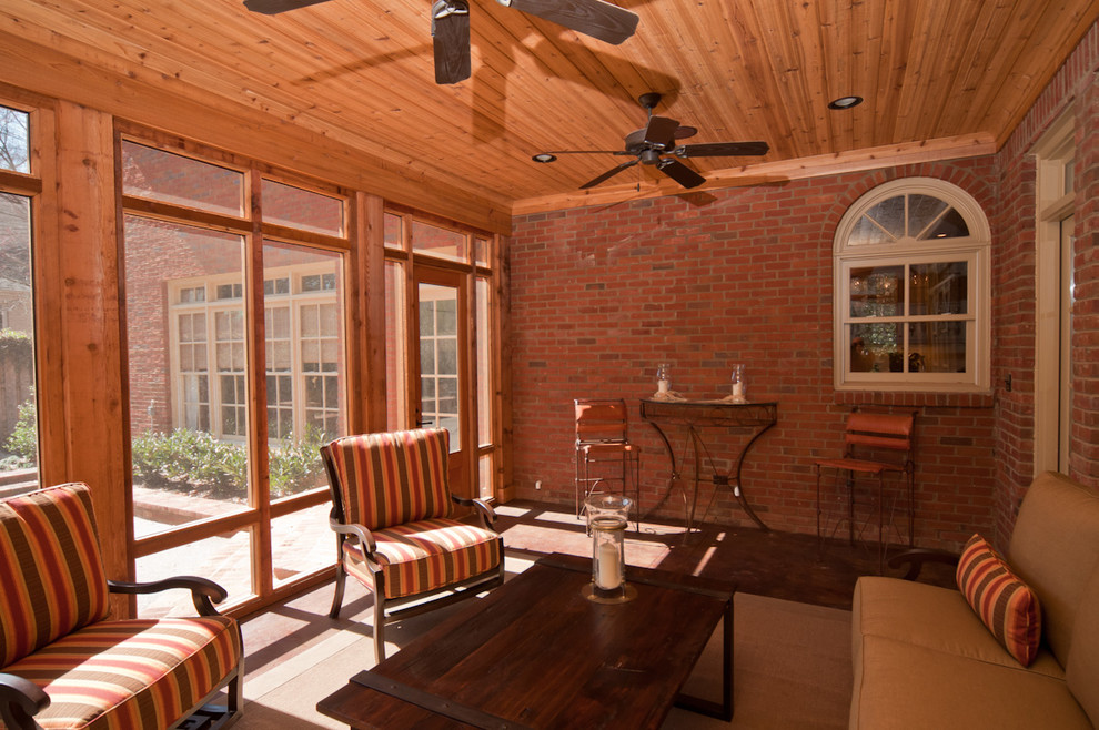 Cette image montre un petit porche d'entrée de maison arrière avec une moustiquaire, du béton estampé et une extension de toiture.