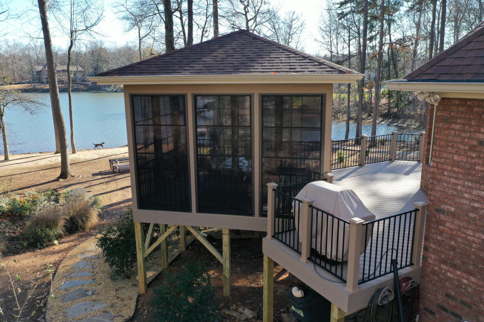 Large trendy screened-in back porch photo in Charlotte with decking and a roof extension
