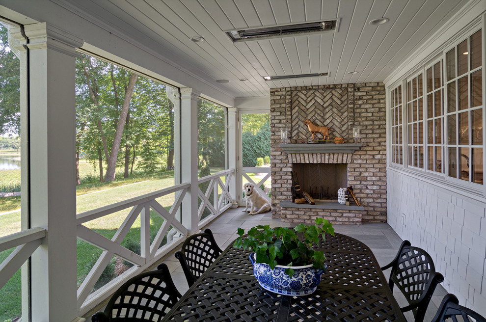 Inspiration pour un porche d'entrée de maison arrière traditionnel de taille moyenne avec une cheminée, des pavés en béton et une extension de toiture.