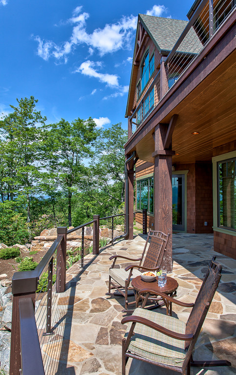 Imagen de terraza de estilo americano grande en patio trasero con adoquines de piedra natural y barandilla de cable
